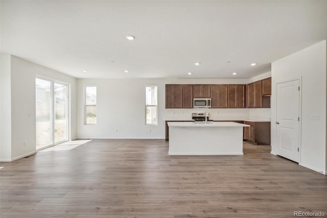 13392 E 110th Way, Commerce City, CO 80022 - kitchen featuring appliances with stainless steel finishes, open floor plan, light wood-style flooring, recessed lighting, and light countertops