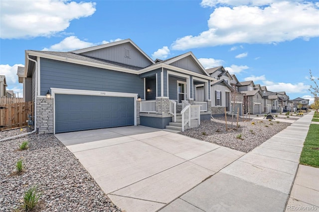 13392 E 110th Way, Commerce City, CO 80022 - view of front of property with covered porch, concrete driveway, a garage, a residential view, and stone siding