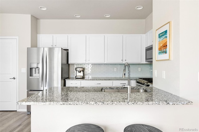14833 E Crestridge Dr, Centennial, CO 80015 - kitchen with a sink, appliances with stainless steel finishes, light stone countertops, a kitchen breakfast bar, and recessed lighting