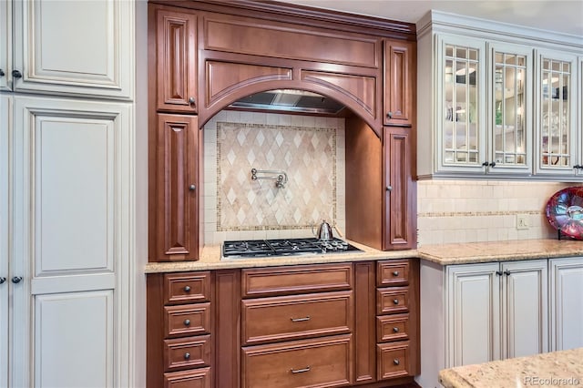 10130 E Powers Ave, Greenwood Village, CO 80111 - kitchen with backsplash, stainless steel gas cooktop, and glass insert cabinets