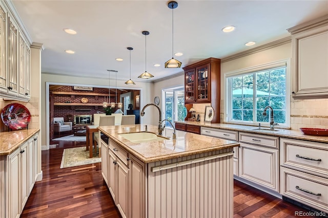 10130 E Powers Ave, Greenwood Village, CO 80111 - kitchen with crown molding, cream cabinetry, glass insert cabinets, light stone countertops, and backsplash