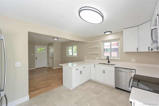 kitchen featuring sink, appliances with stainless steel finishes, kitchen peninsula, and a wealth of natural light