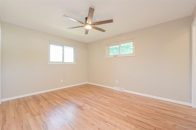 spare room featuring light hardwood / wood-style flooring, ceiling fan, and plenty of natural light