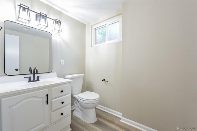 bathroom featuring baseboards, toilet, vanity, and wood finished floors