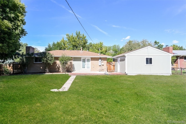 back of property with fence, french doors, and a yard