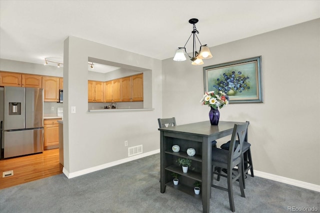 13271 Holly St Unit B, Thornton, CO 80241 - carpeted dining space featuring a chandelier and baseboards