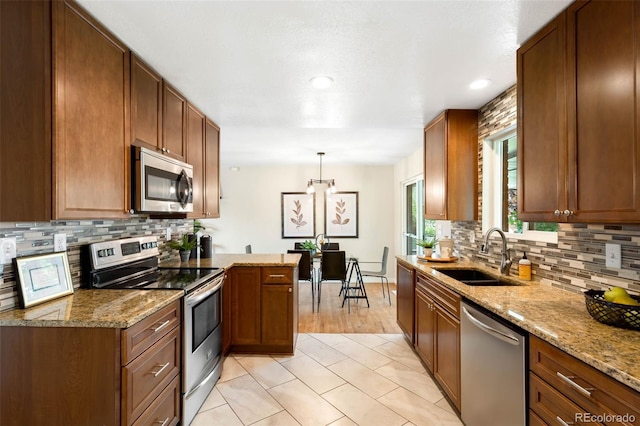 9325 Meade St, Westminster, CO 80031 - kitchen featuring appliances with stainless steel finishes, tasteful backsplash, light stone counters, brown cabinets, and recessed lighting