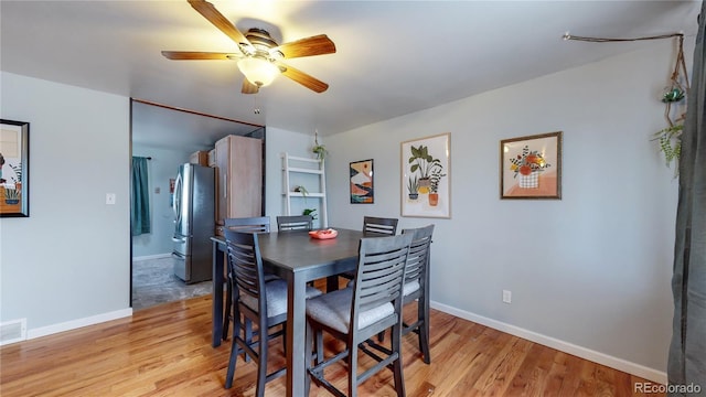 dining space with ceiling fan and light hardwood / wood-style flooring