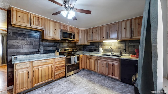 kitchen featuring appliances with stainless steel finishes, sink, decorative backsplash, ceiling fan, and light stone counters