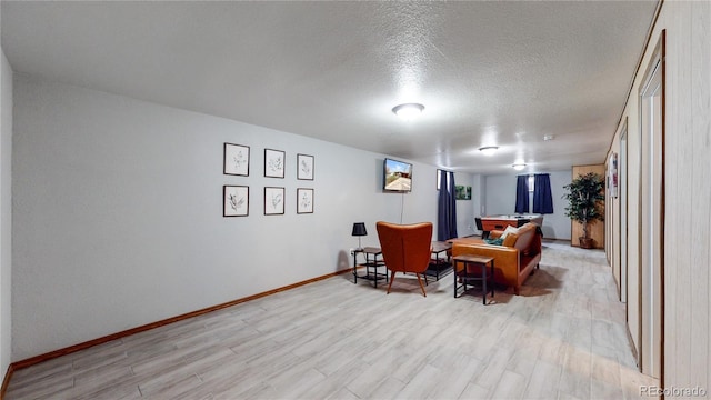 sitting room featuring light hardwood / wood-style flooring and a textured ceiling