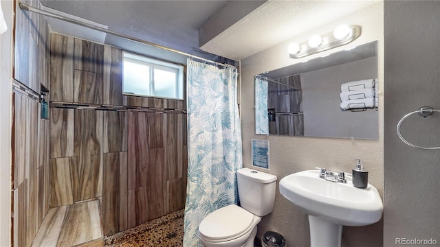 bathroom featuring sink, curtained shower, and toilet