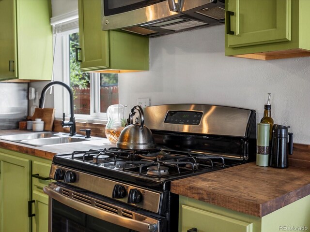 3134 W Center Ave, Denver, CO 80219 - kitchen featuring stainless steel appliances, green cabinets, butcher block countertops, and a sink
