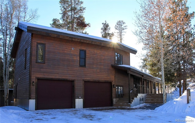 view of snow covered exterior with a garage