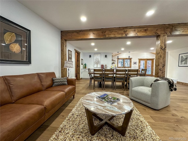 living room featuring beamed ceiling and wood-type flooring