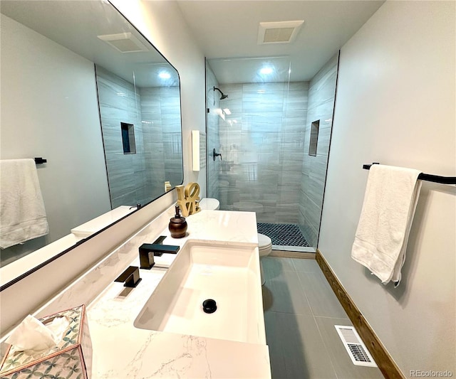 bathroom with tile patterned floors, vanity, an enclosed shower, and toilet