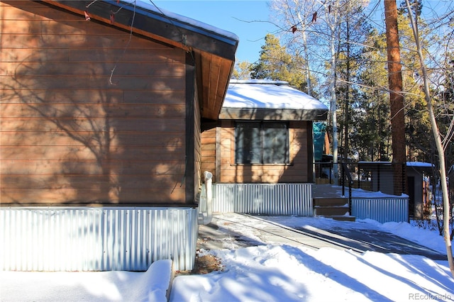 snow covered property with a wooden deck