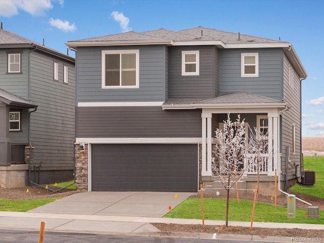 view of front of home with central AC unit and a garage