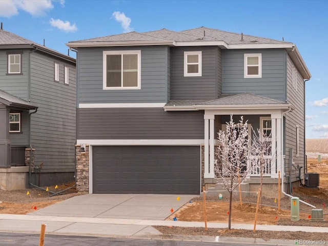 view of front of house featuring a garage and central AC