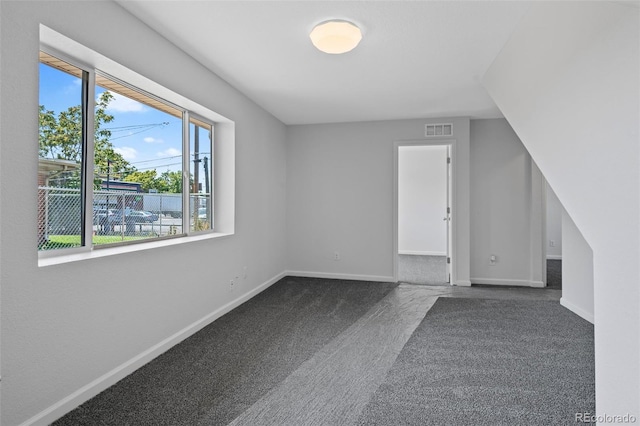 bonus room featuring dark carpet