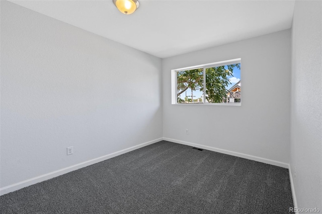 empty room featuring dark colored carpet