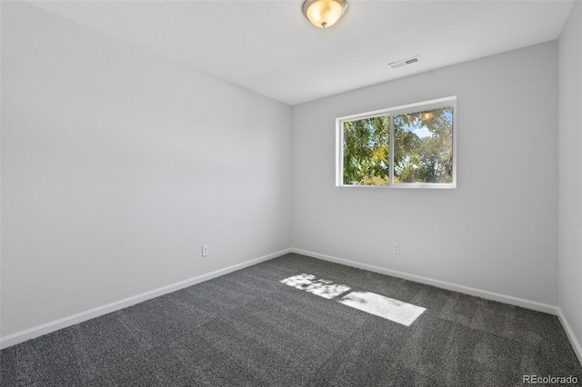 empty room featuring dark carpet