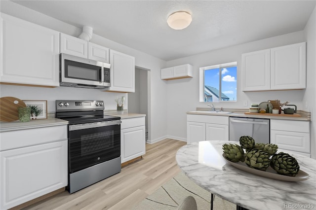 kitchen with white cabinets, sink, and appliances with stainless steel finishes