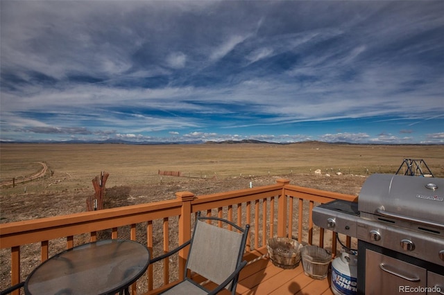 wooden terrace with area for grilling and a rural view