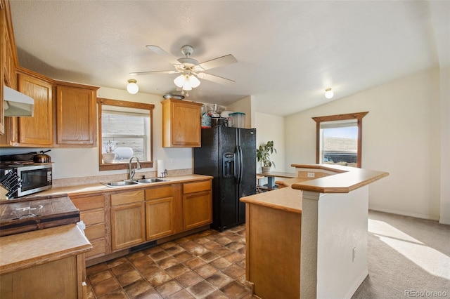 kitchen featuring sink, black fridge, ceiling fan, a center island with sink, and exhaust hood