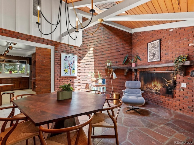 10400 W 35th Pl, Wheat Ridge, CO 80033 - dining room featuring brick wall, a high ceiling, stone tile floors, a brick fireplace, and beam ceiling