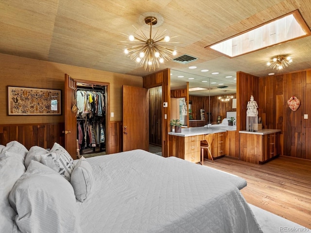10400 W 35th Pl, Wheat Ridge, CO 80033 - bedroom with wooden walls, a chandelier, light wood finished floors, wood ceiling, and a skylight