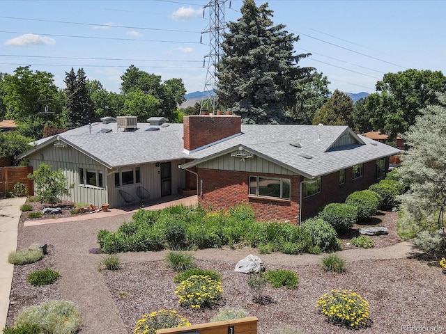 10400 W 35th Pl, Wheat Ridge, CO 80033 - ranch-style house with a chimney, brick siding, a shingled roof, and board and batten siding