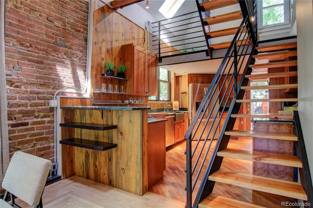 3259 W Hayward Pl, Denver, CO 80211 - stairway with a towering ceiling, brick wall, and wood finished floors