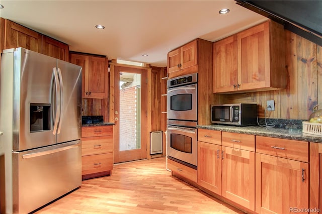 3259 W Hayward Pl, Denver, CO 80211 - kitchen featuring appliances with stainless steel finishes, light wood-style floors, recessed lighting, dark stone countertops, and brown cabinets