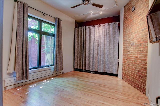 3259 W Hayward Pl, Denver, CO 80211 - spare room with brick wall, track lighting, baseboard heating, wood finished floors, and ceiling fan