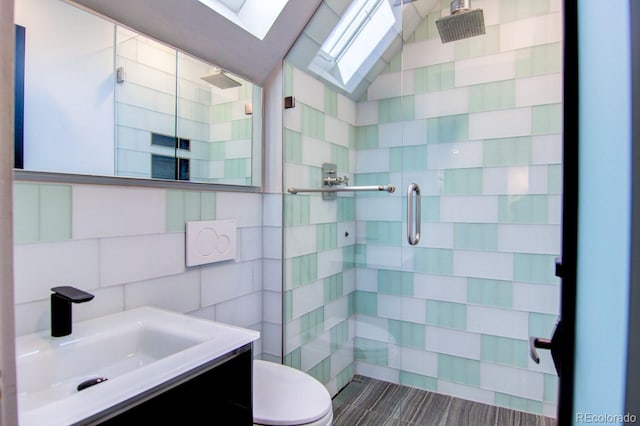 3259 W Hayward Pl, Denver, CO 80211 - full bathroom with tile walls, a shower stall, a skylight, vanity, and lofted ceiling