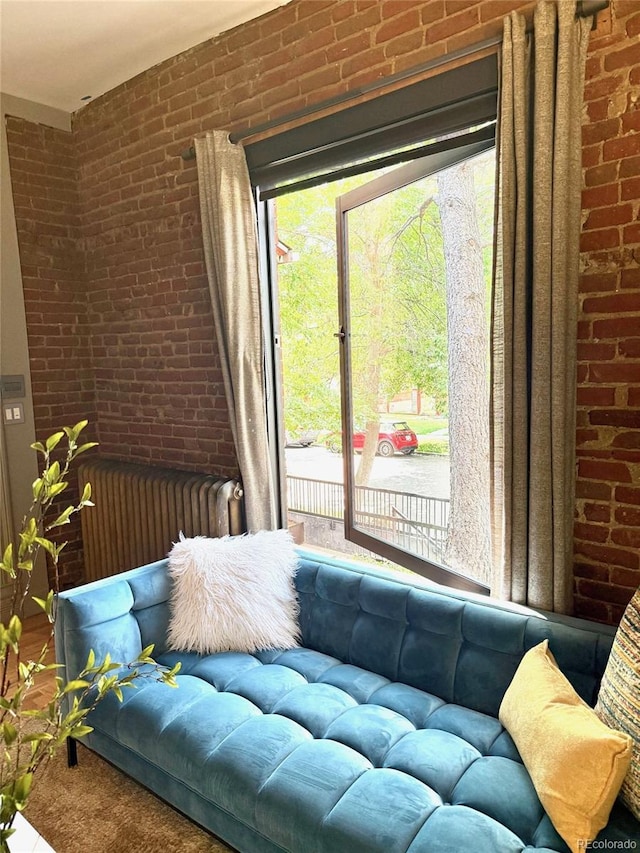 3259 W Hayward Pl, Denver, CO 80211 - living room with brick wall, radiator heating unit, and carpet flooring
