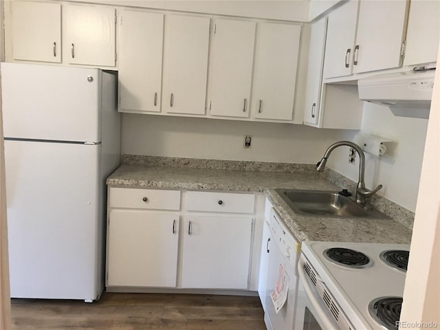 kitchen with a sink, white appliances, wood finished floors, and light countertops