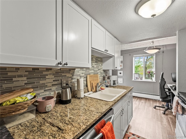 100 S Clarkson St Unit 202, Denver, CO 80209 - kitchen with a baseboard heating unit, tasteful backsplash, light wood-style floors, an office area, and white cabinetry