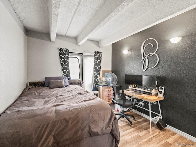 100 S Clarkson St Unit 202, Denver, CO 80209 - bedroom with light wood-type flooring, beam ceiling, a textured ceiling, and a desk