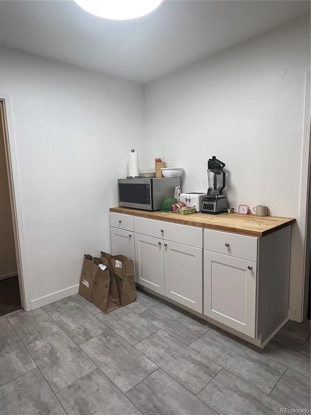 938 Racine St, Aurora, CO 80011 - bar area featuring stainless steel microwave and baseboards
