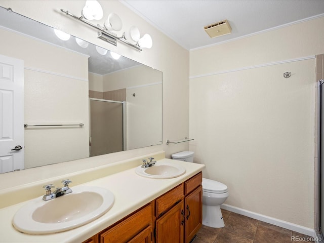 full bath with toilet, a shower stall, double vanity, and a sink