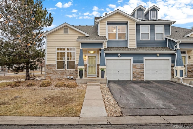 view of front of home with stone siding, roof with shingles, driveway, and an attached garage