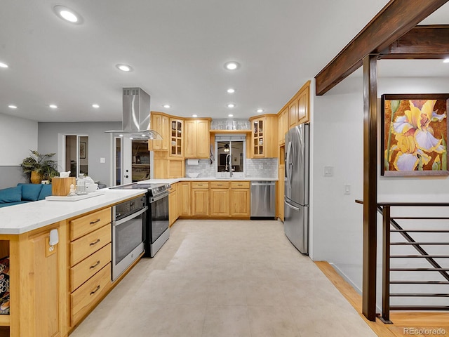 kitchen featuring sink, light brown cabinets, island exhaust hood, decorative backsplash, and appliances with stainless steel finishes