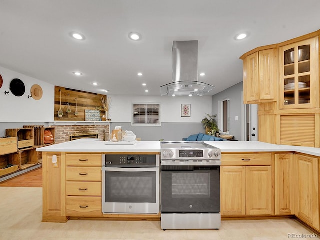 kitchen featuring light brown cabinets, stainless steel appliances, light tile patterned floors, and island range hood