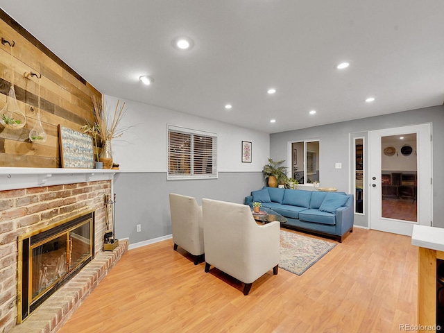 living room with light hardwood / wood-style flooring and a brick fireplace