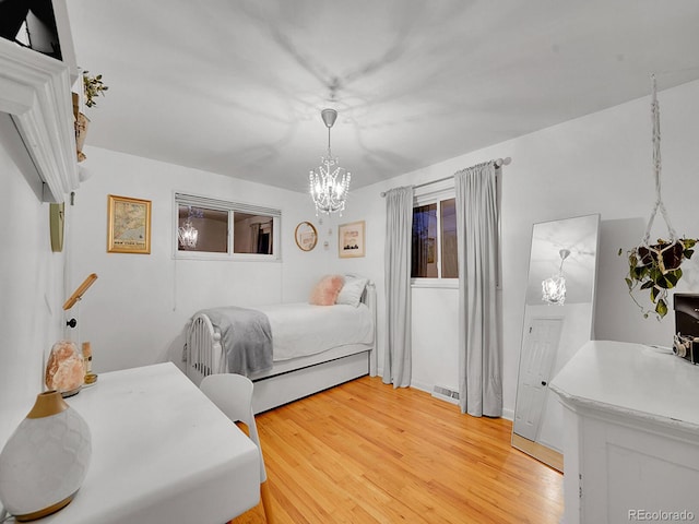 bedroom with a notable chandelier and wood-type flooring