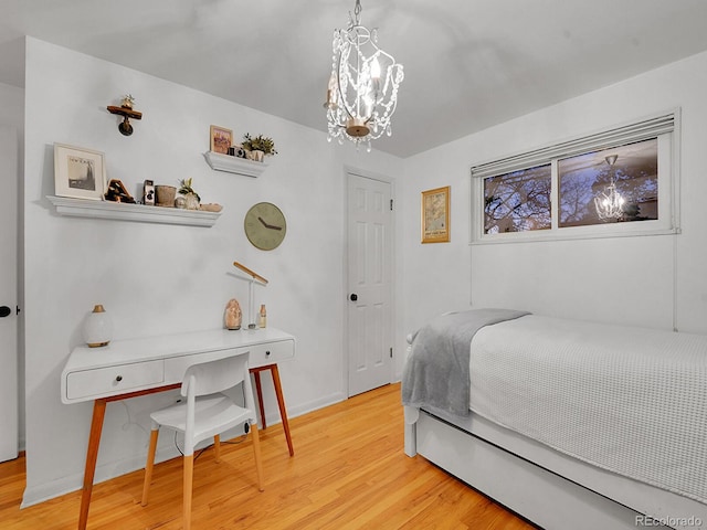 bedroom with an inviting chandelier and light hardwood / wood-style flooring