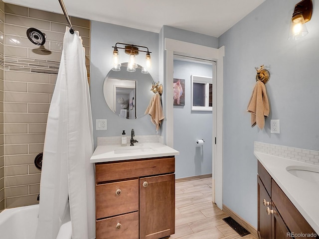 bathroom featuring hardwood / wood-style floors, vanity, and shower / bath combo