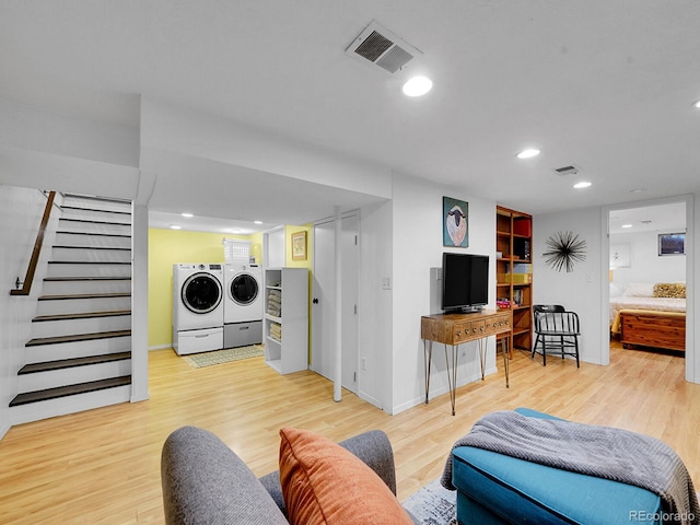 living room featuring independent washer and dryer and light hardwood / wood-style flooring