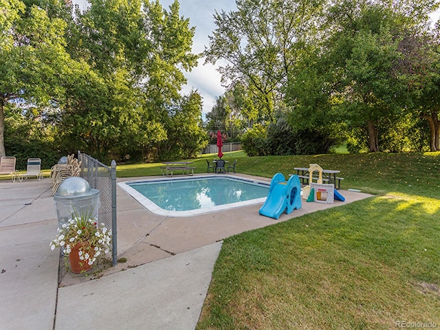 view of swimming pool with a lawn and a patio